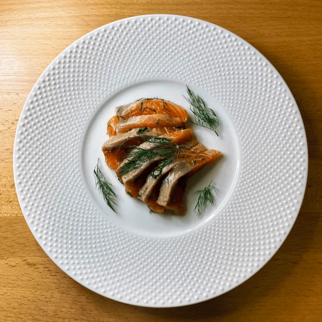 皿に盛られたグラブラックスと添え物のディル